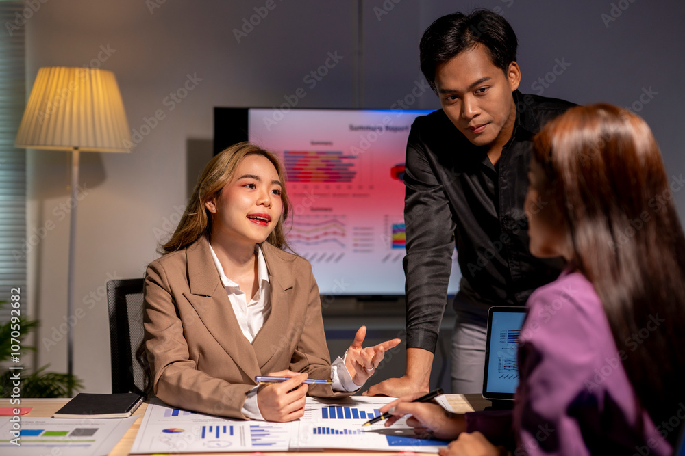 Fototapeta premium Group of asian businesspeople working late together in the office discussing, brainstorming, finding solutions for new target project