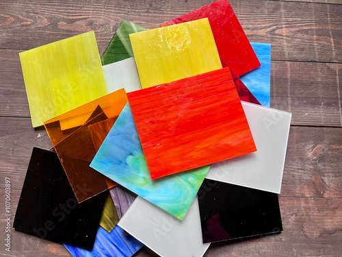 Working with colored glass for stained glass samples for creativity square colored pieces of glass on the table as a background