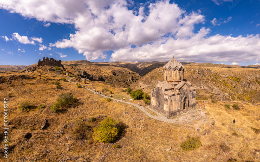 Fototapeta premium Aerial drone view of famous Vahramashen Church of the 11th century, located near destroyed Amberd fortress in sunny summer day. Cliff with Arkashian River deep in canyon. Aragatsotn region, Armenia