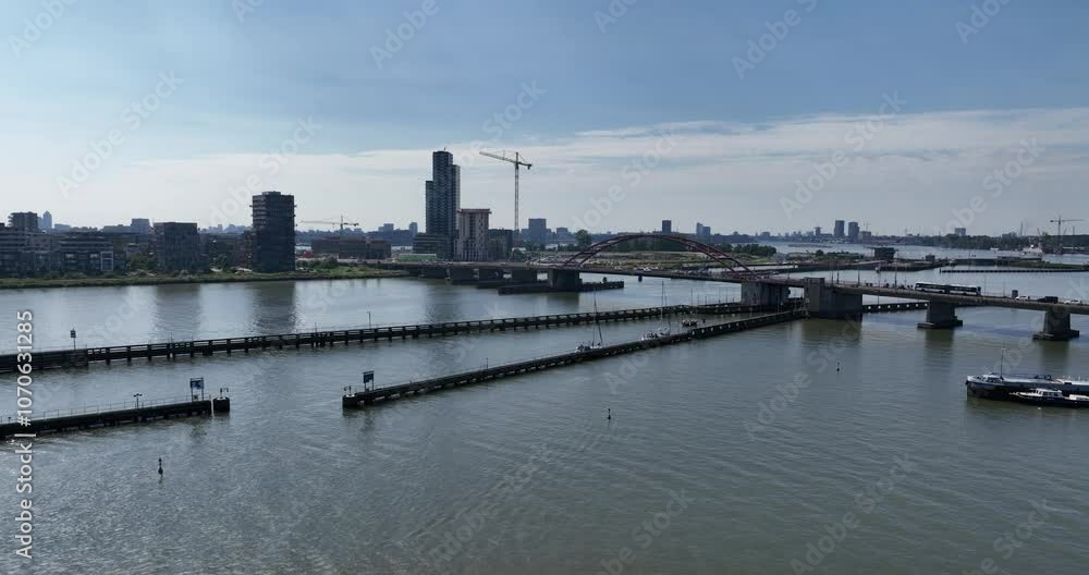 Drone ascending on river with Schellingwouderbrug bridge, showing buildings in the background Drone ascending on river with Schellingwouderbrug bridge, showing buildings in the background