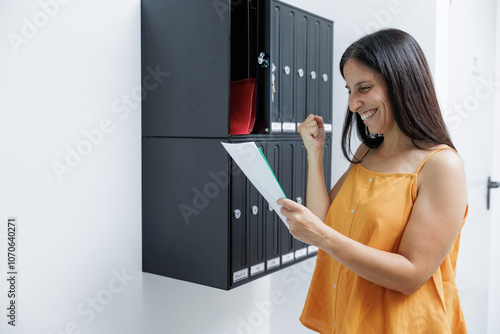 Woman looks at the correspondence in her mailbox and receives the long-awaited notifications, receives good news or from a relative she has not seen for a long time.