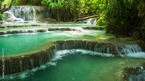 Turquoise tranquil pools cascade through lush greenery in a remote tropical paradise beneath sunlit waterfalls