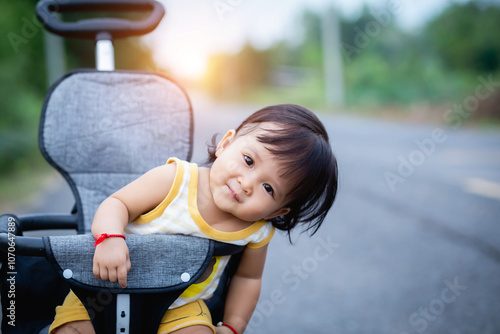 Young asian woman mother, walking with baby stroller in park