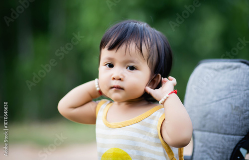 Young asian woman mother, walking with baby stroller in park