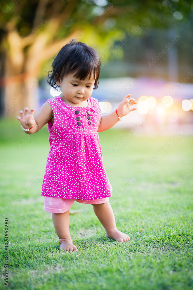 Baby girl walking outdoors dressed in pink stripped dress. Happy kid. Happy childhood. Baby girl walking outdoors dressed in pink stripped dress. Happy kid. Happy childhood.