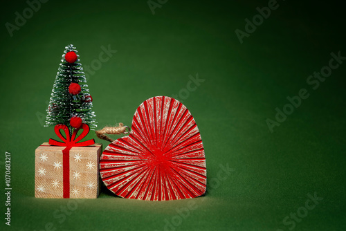 Ein Weihnachtsbaum mit Geschenk und einem Herz vor einem grünen Hintergrund