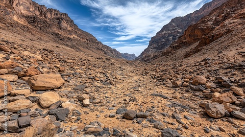 Rocky desert canyon with blue sky and clouds.