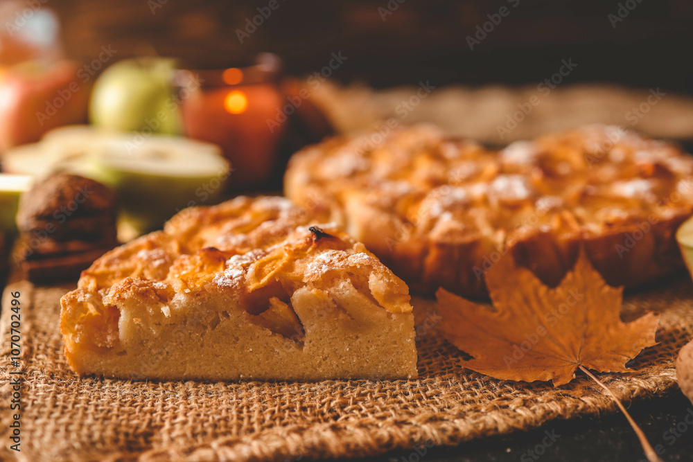 Top view of a freshly baked apple pie surrounded by fresh apples, wooden spoons, a lit candle, and cozy autumn elements on a warm-toned background. Perfect for fall and Thanksgiving themes Top view of a freshly baked apple pie surrounded by fresh apples, wooden spoons, a lit candle, and cozy autumn elements on a warm-toned background. Perfect for fall and Thanksgiving themes