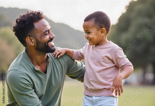 Handsome African American father in his 30s playing and smiling with his young son  photo