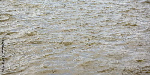 Muddy brown water surface with small waves 