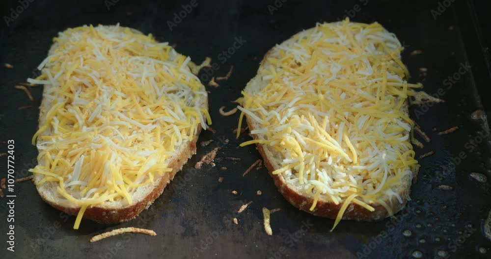 Closeup of two tasty cheese melting on bread on a griddle