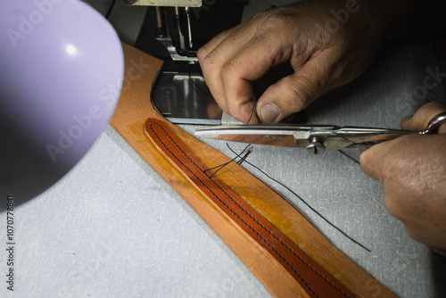 A saddler craftsman restores and creates animal harnesses and tack with leather. He cuts, glues, sews, paints.