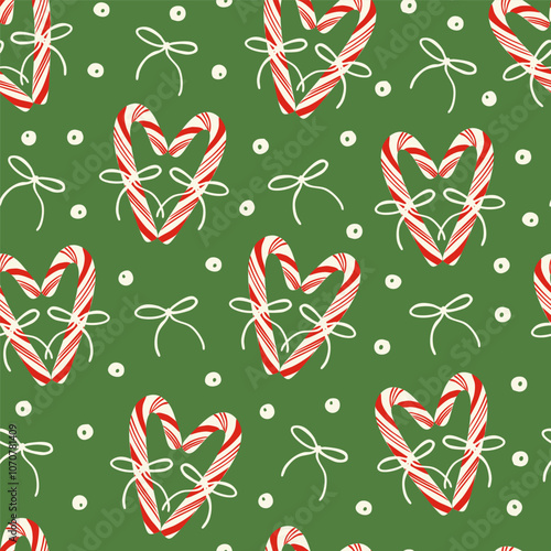 Cute red candy canes with bows, berries and holly plant berries seamless pattern on green. Holiday season festive background. Elegant design for wrapping paper, fabric.