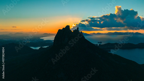 Sunrise from the peak of Tetakawi Mountain overlooking the bay of San Carlos Sonora, Mexico. The rising sun on the horizon paints the sky in warm tones. photo