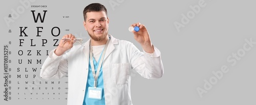 Male ophthalmologist with eyeglasses and contact lenses on grey background wi...