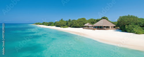 Secluded luxury resort with cabanas on a beautiful white sand beach, surrounded by clear turquoise waters and lush tropical greenery