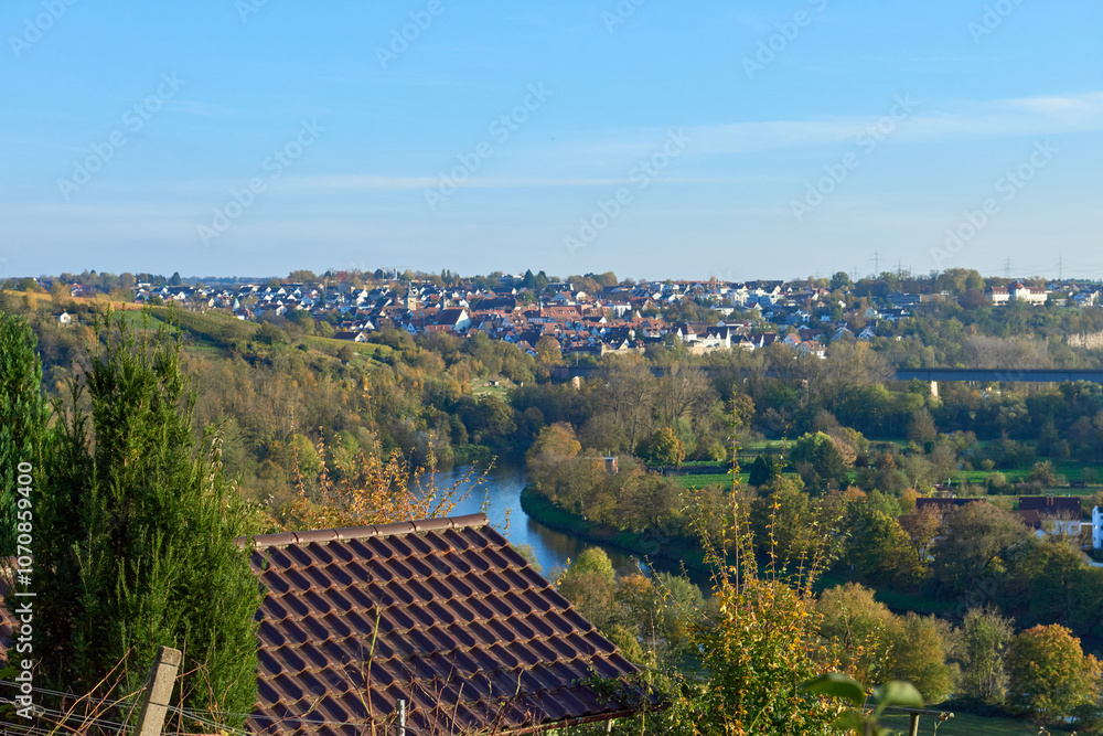 A Serene River Landscape Capturing the Beauty of Fall Foliage and a Charming Town View A Serene River Landscape Capturing the Beauty of Fall Foliage and a Charming Town View