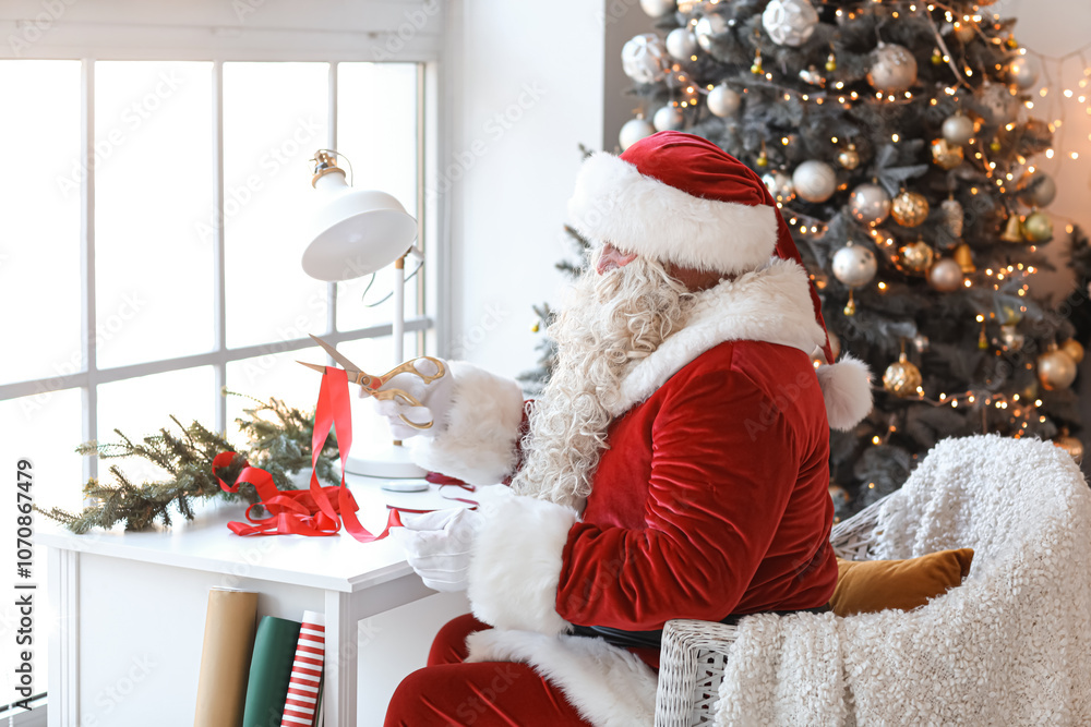 Obraz premium Santa Claus making Christmas gift at home