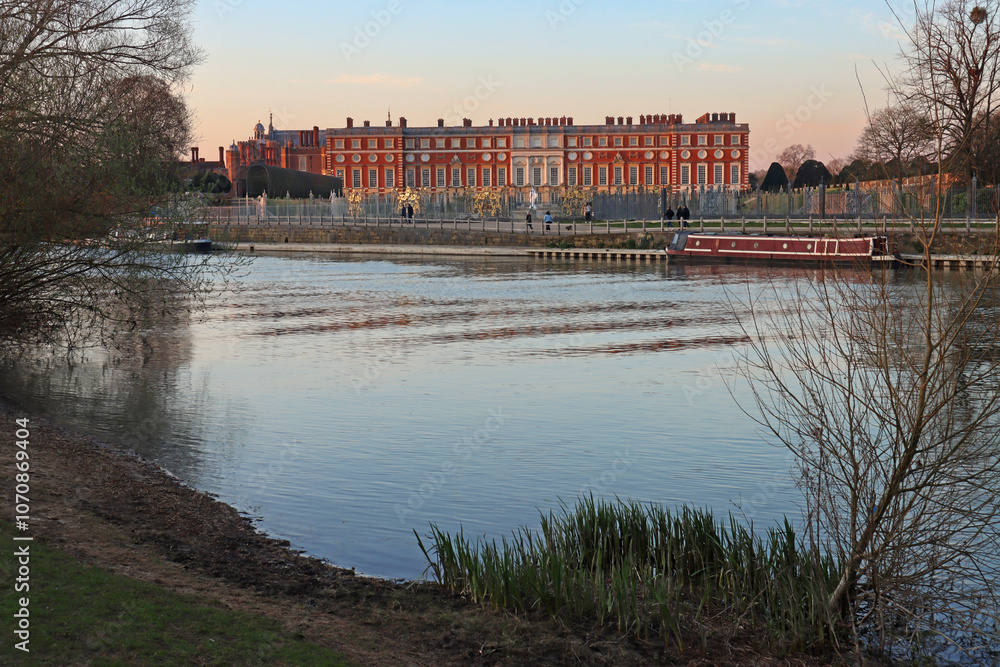 Fototapeta premium Georgian facade of Hampton Court Palace reflected in, and viewed from, the River Thames