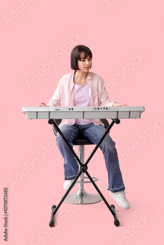 Young woman playing synthes...