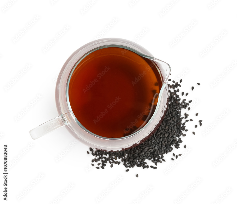 Glass jug of oil with sesame seeds on white background Glass jug of oil with sesame seeds on white background