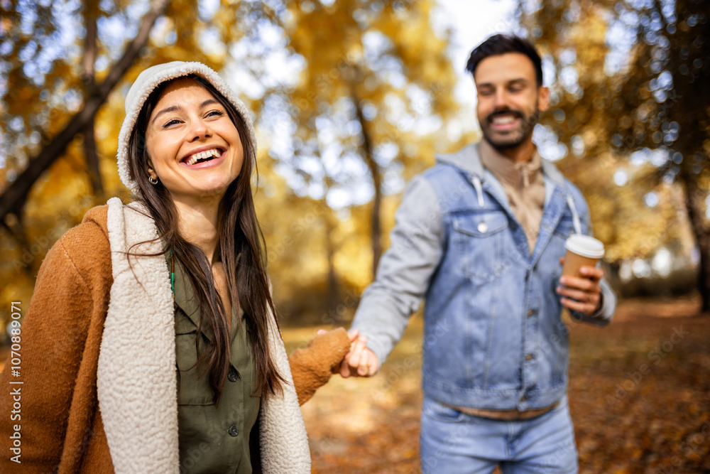 Pretty young couple drinking coffee in the park. Colorful autumn vibes in the park. Hugging, walking and holding hands. Pretty young couple drinking coffee in the park. Colorful autumn vibes in the park. Hugging, walking and holding hands.