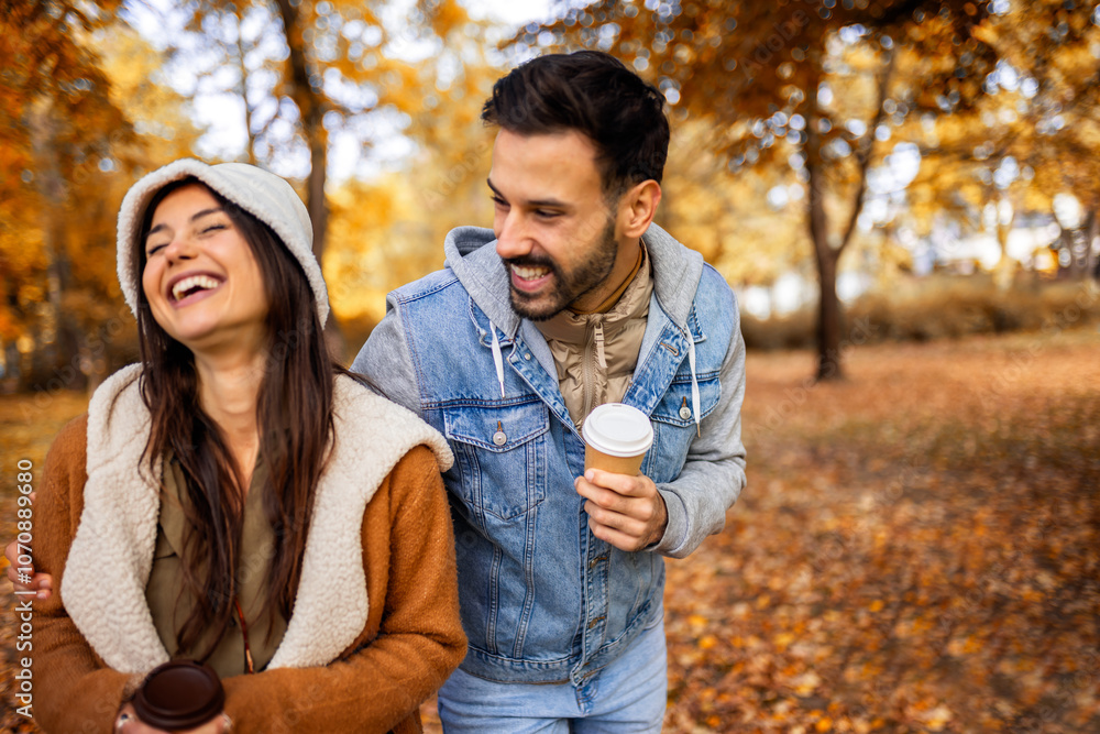 Pretty young couple drinking coffee in the park. Colorful autumn vibes in the park. Hugging, walking and holding hands. Pretty young couple drinking coffee in the park. Colorful autumn vibes in the park. Hugging, walking and holding hands.