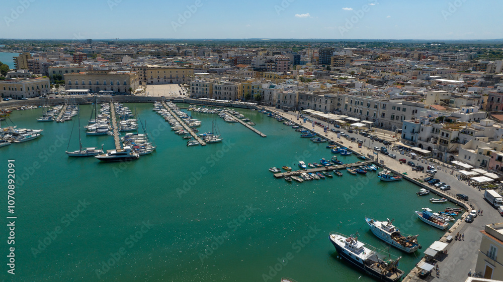 Fototapeta premium Aerial view of the port of the city of Trani, in Puglia, Italy. It is a small tourist seaport on the Adriatic Sea. There are many boats anchored in the clean water of the harbour.