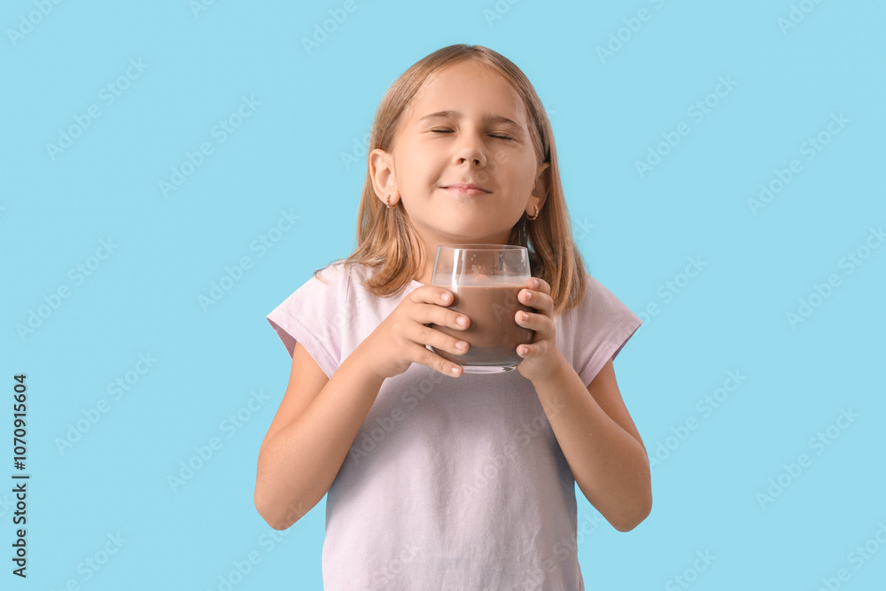 Cute little girl with glass of sweet chocolate milk on blue background Cute little girl with glass of sweet chocolate milk on blue background