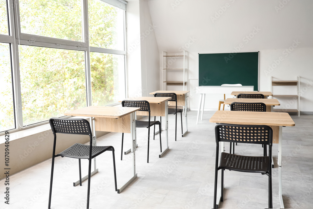 Fototapeta premium Interior of empty classroom with blackboard and desks