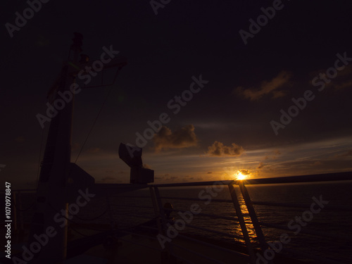 View of the sun setting from the front of a cruise ship
