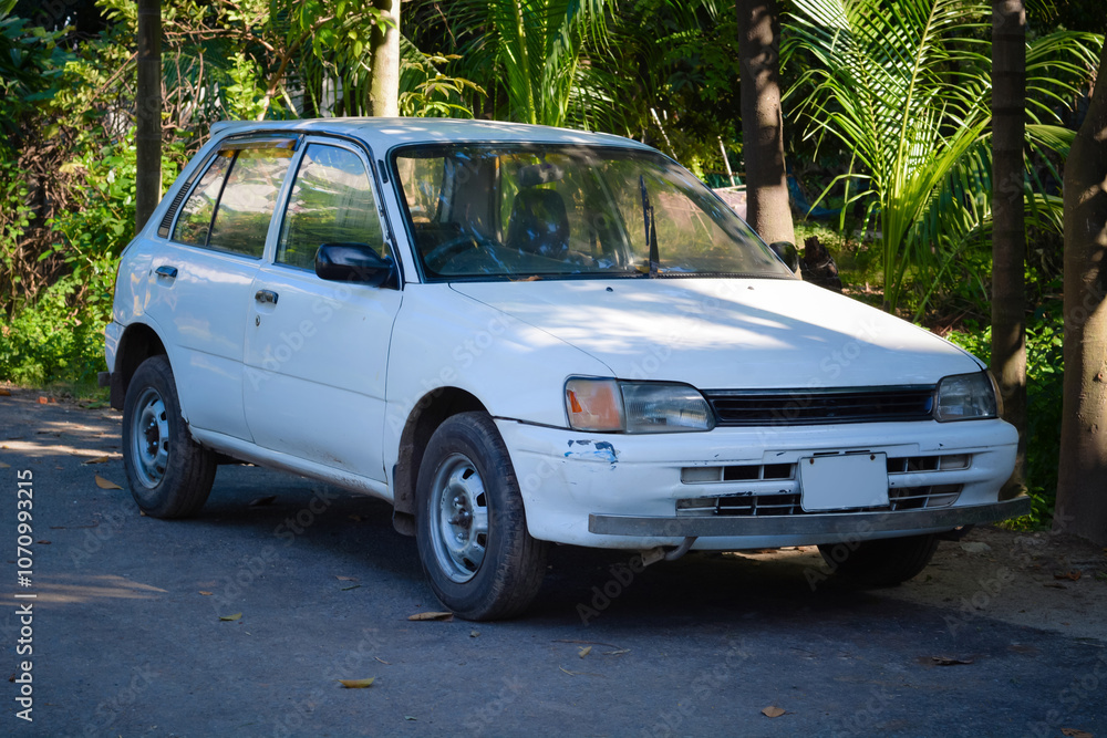 A Classic White Hatchback Parked Along a Tree-Lined Street in the Late Afternoon Light A Classic White Hatchback Parked Along a Tree-Lined Street in the Late Afternoon Light