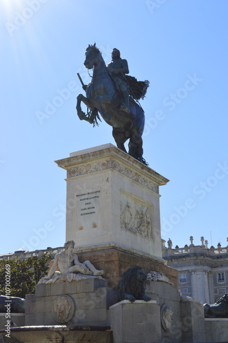 Sol brilhando sob escultura de cavaleiro em Madrid photo