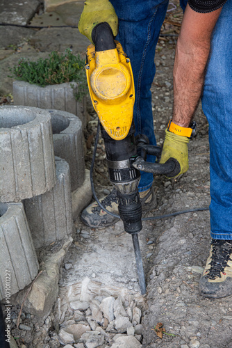 Foto Details of construction site with worker using pneumatic jackhammer for demolish