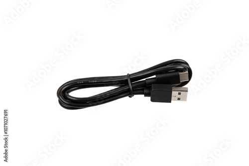 Fotografie Black USB cable with two connectors, neatly coiled and secured with a strap, isolated on a white background