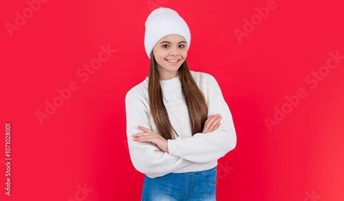 positive teen girl in winter knitwear sweater in studio. teen winter girl isolated on red photo