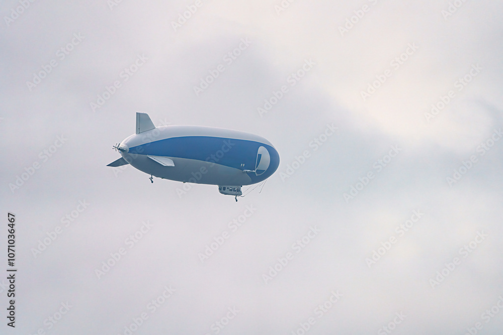 A tourist airship with passengers on board travels through the sky. A tourist airship with passengers on board travels through the sky.