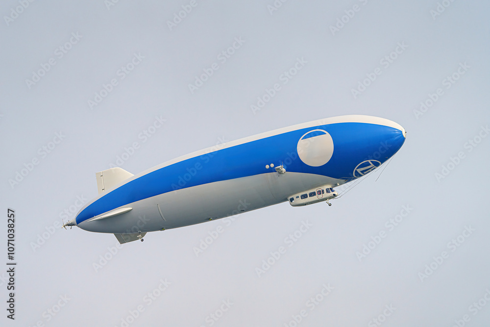 A tourist airship with passengers on board travels through the sky. A tourist airship with passengers on board travels through the sky.