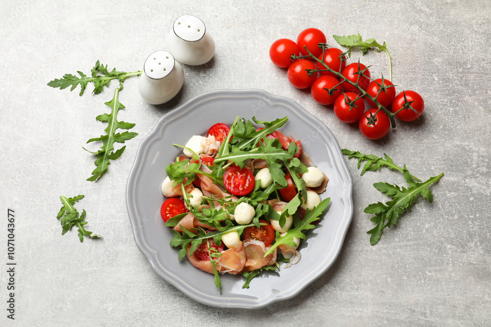 Tasty salad with arugula on grey textured table, flat lay Tasty salad with arugula on grey textured table, flat lay