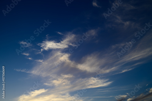 Beautiful wispy clouds dance across the evening sky at twilight, creating a stunning backdrop for reflection