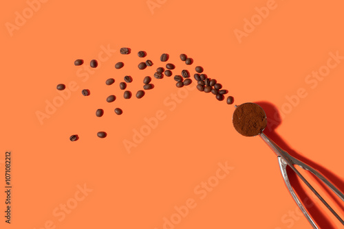 Ground coffee in an ice cream scoop on a orange background photo