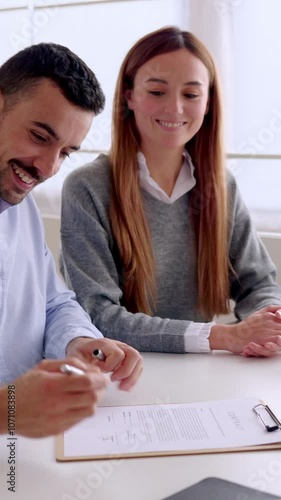 Vertical HD video of happy smiling millennial couple handshaking with senior female real estate agent meeting in the office after signing deal or contract.