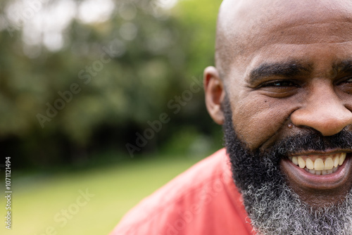 Smiling man enjoying sunny day outdoors, feeling joyful and relaxed, copy space photo