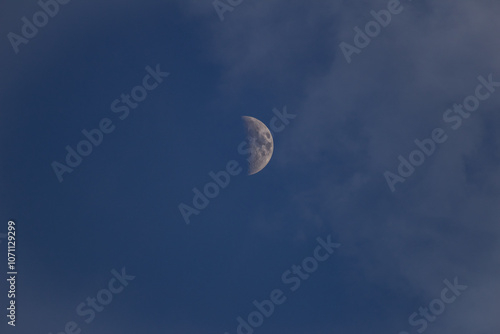 Moon in the blue sky with white clouds, closeup of photo photo