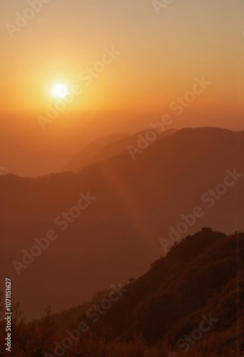 Golden sunrise illuminating misty mountain ranges at dawn photo