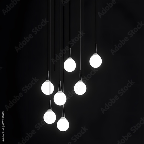 A cluster of seven round white pendant lights against a black background. photo