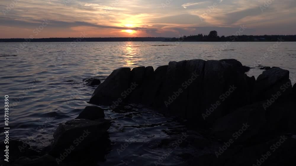 Stunning sunset over calm waters with rocky Acadia National Park shoreline Stunning sunset over calm waters with rocky Acadia National Park shoreline