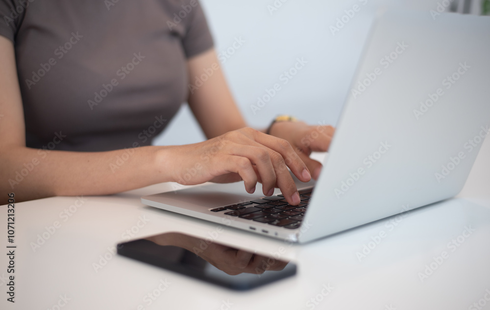 Woman typing on laptop computer on white table, close up. Casual business woman online working, surfing the internet at home office, remote work concept Woman typing on laptop computer on white table, close up. Casual business woman online working, surfing the internet at home office, remote work concept