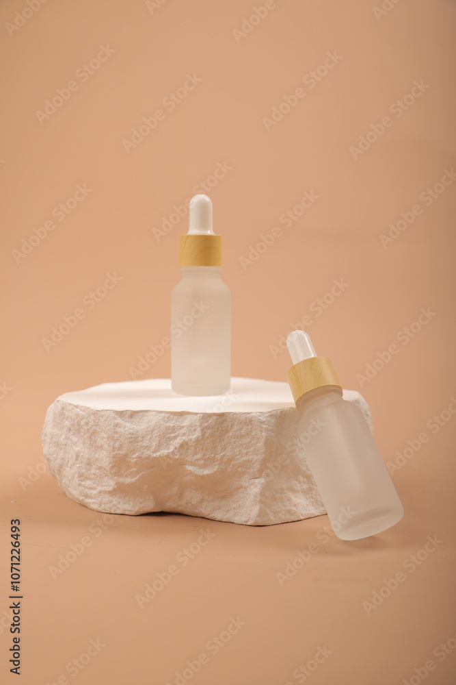 Frosted Glass Dropper Bottles with Yellow Caps on Natural Stone and Neutral Background Frosted Glass Dropper Bottles with Yellow Caps on Natural Stone and Neutral Background