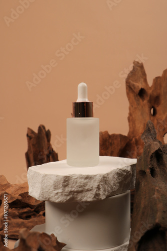 Frosted Glass Dropper Bottle on White Pedestal with Rustic Wooden Background photo